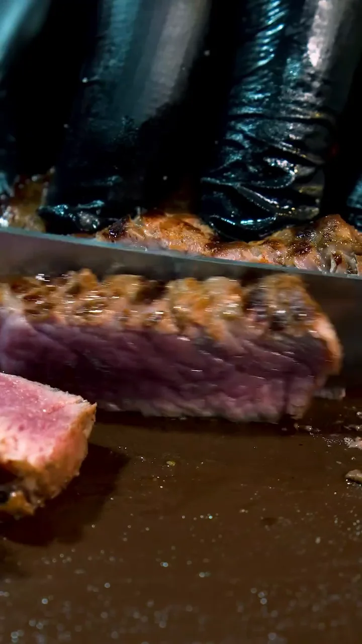 Close da carne sendo fatiada na tábua de preparo