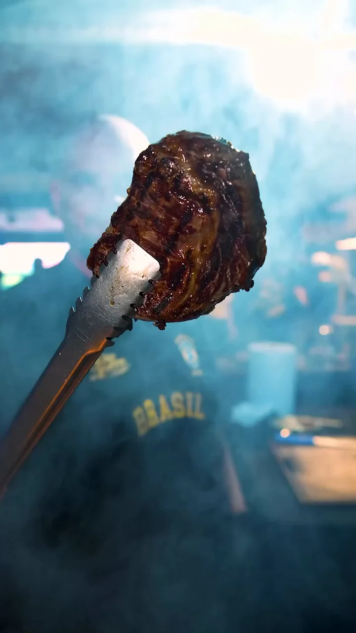 Carne preparada na brasa sobre a tábua do Fabio Martins